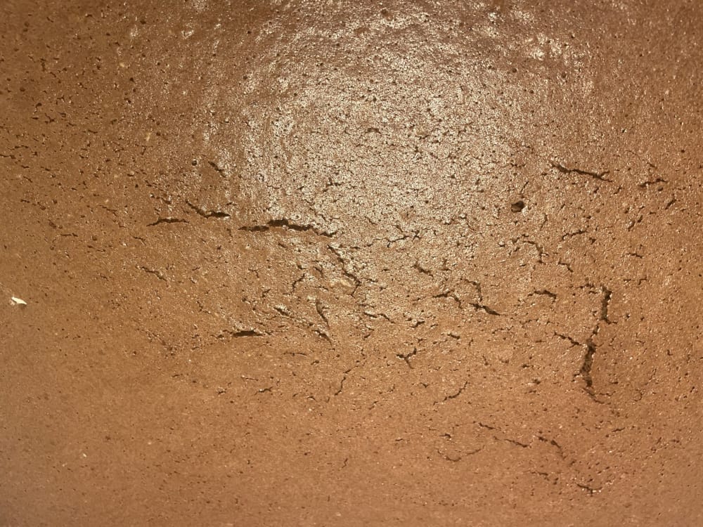 Eine Nahaufnahme von einem Schokoladenkuchen. Er hat ein paar Risse drin.